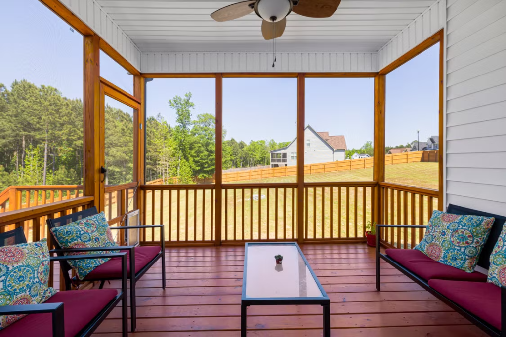 screened porch overlooking a landscaped small backyard with outdoor seating