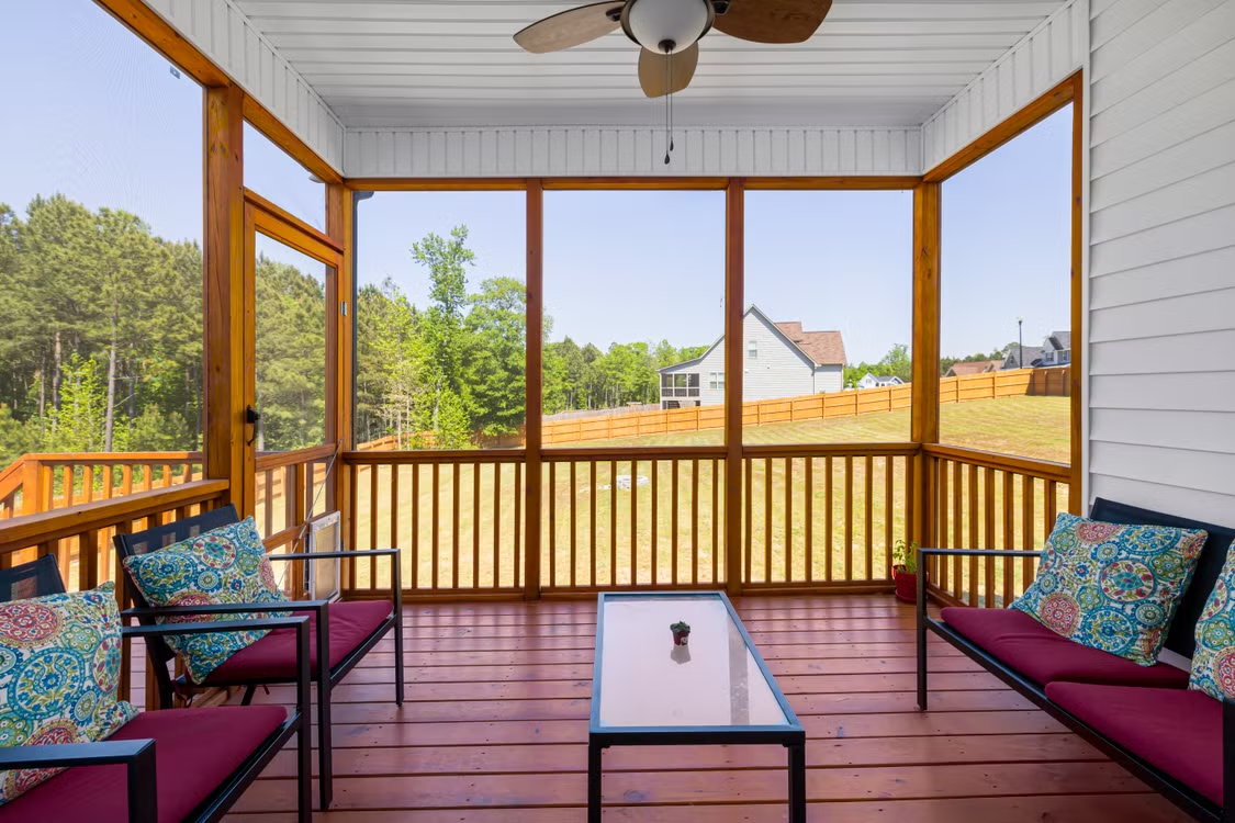 screened porch overlooking a landscaped small backyard with outdoor seating