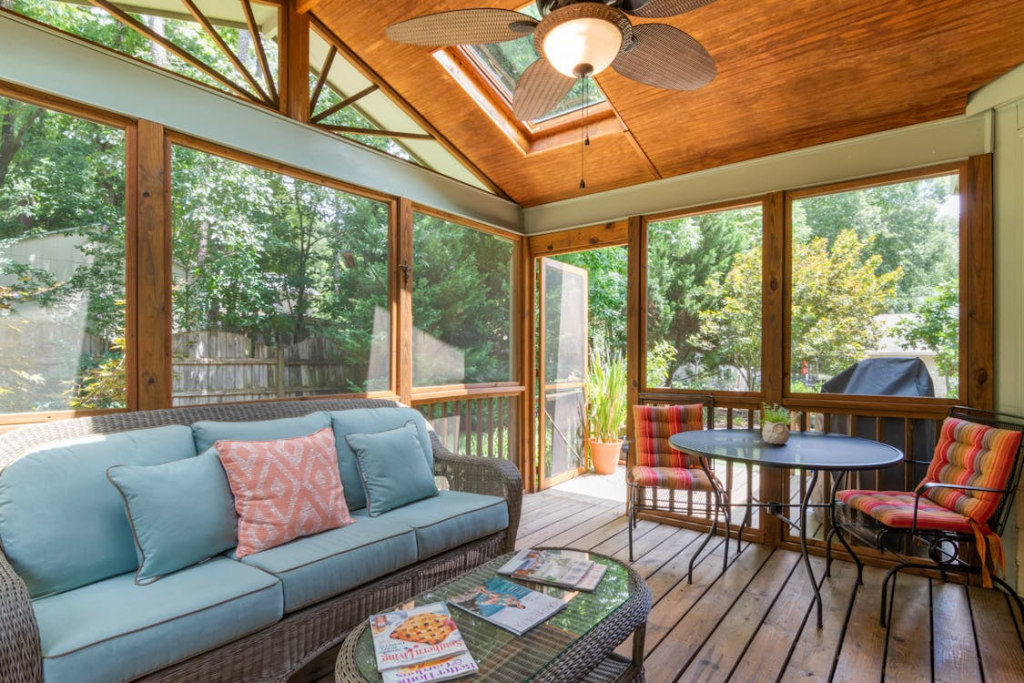 screened in porch lounge area with sofa, cushions, and warm lighting